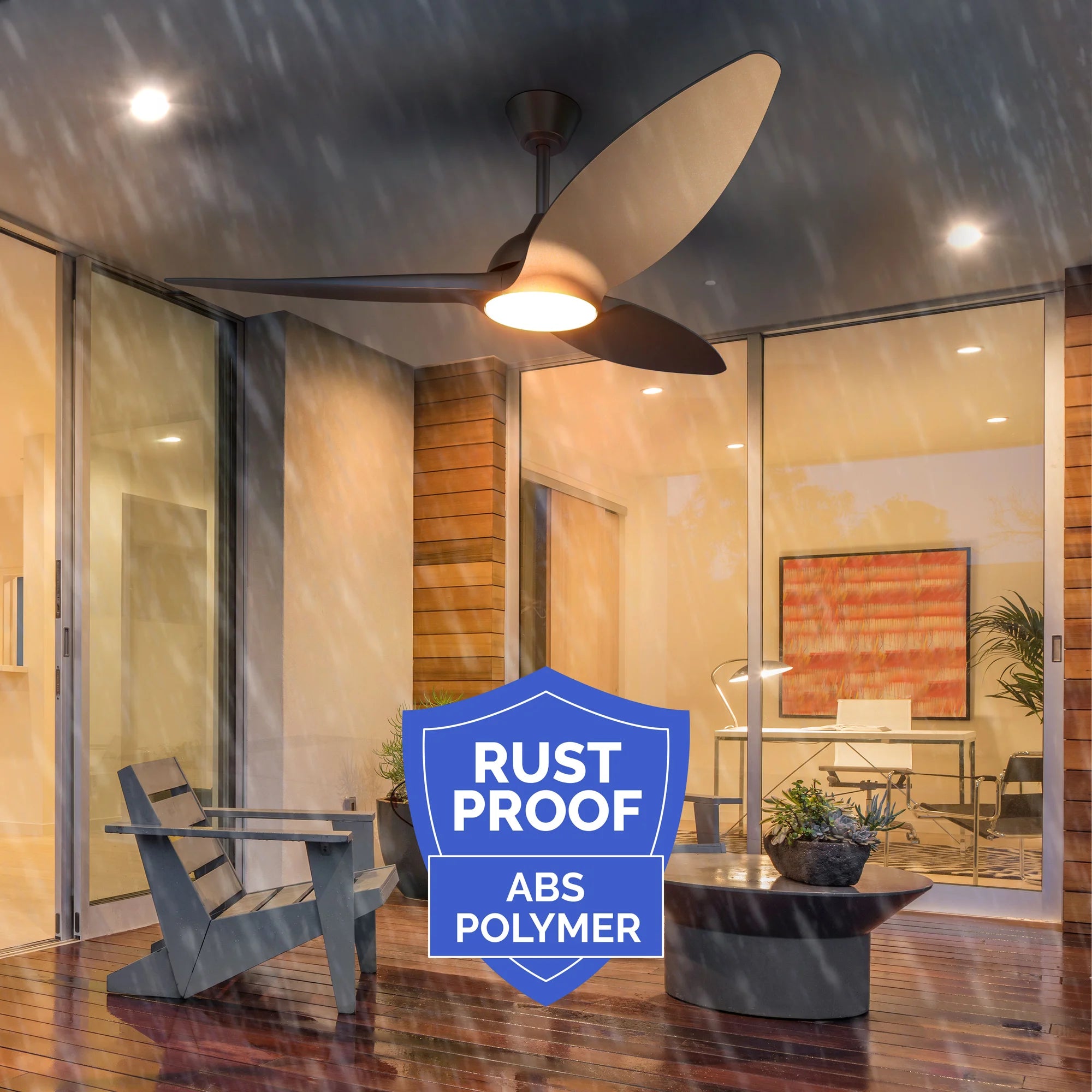 Slique Ceiling Fan running in heavy rain under a covered patio, highlighting rust-proof construction; includes a blue badge that reads "Rust Proof ABS Polymer."
